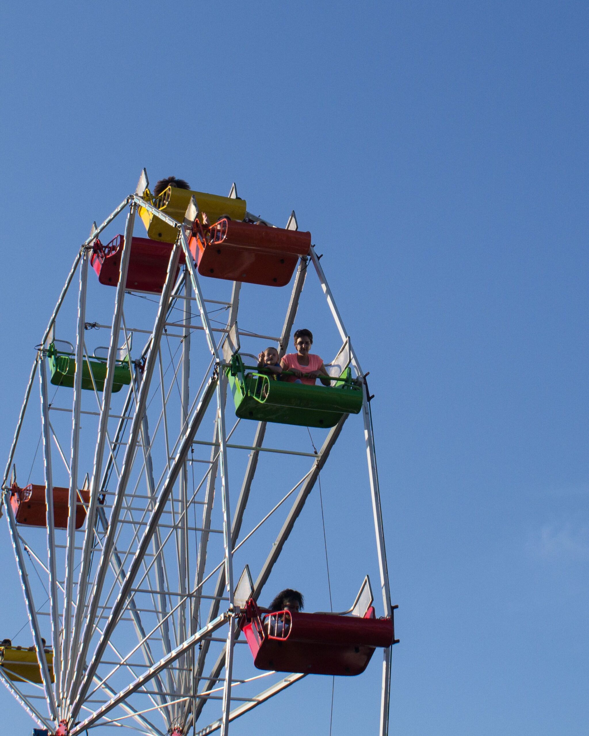 Fairground ferris wheel ride against a blue sky, representing Attractions & Visitor Sites